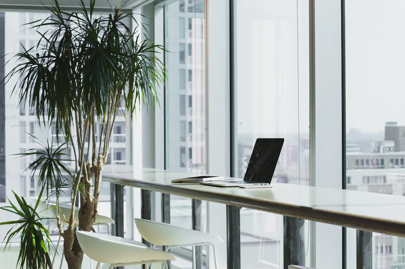 Open office beside large windows with a laptop on a desk